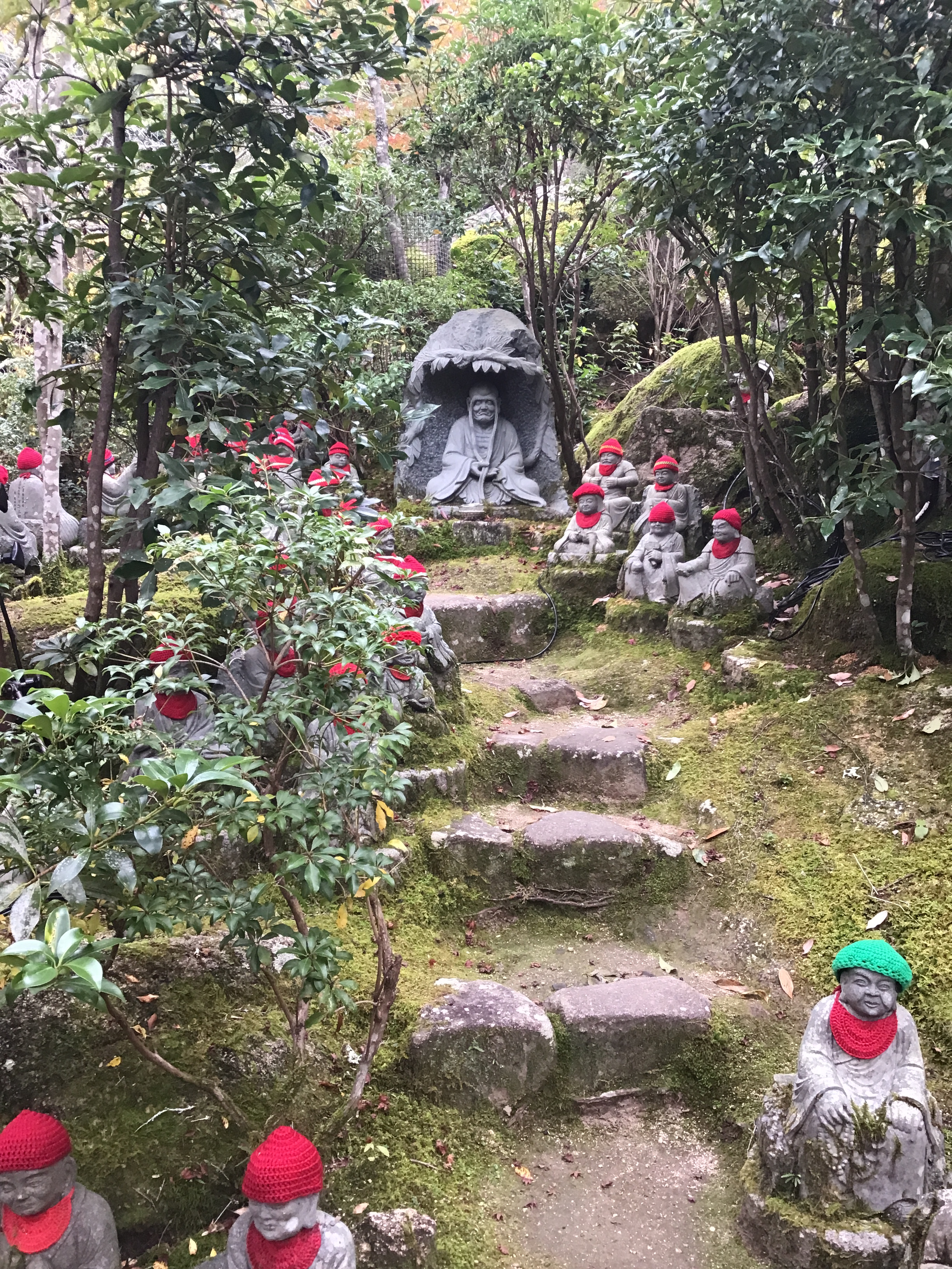 Red hat statues and a larger statue under a shade